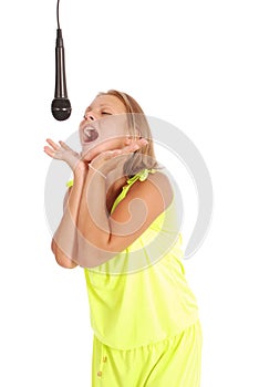 Happy young beautiful girl singing with microphone