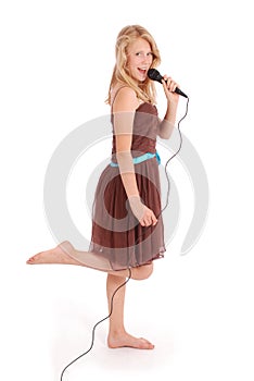 Happy young beautiful girl singing with microphone