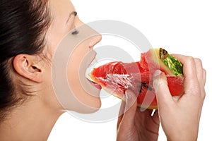 Happy young beautiful woman is eating watermelon.