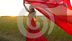 Happy young beautiful woman in red dress with scarf running on wheat field in sunset summer, Freedom health happiness