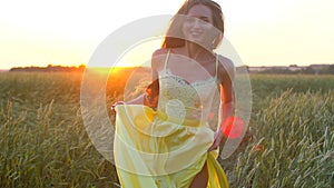 Happy young beautiful woman in yellow dress running on wheat field in sunset summer, Freedom health happiness concept
