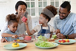 Happy young biracial family with kids cooking together