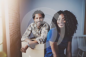 Happy young black african couple moving boxes into new apartment together and making a successful life.Cheerful family