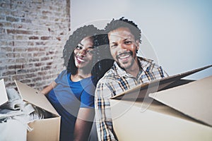 Happy young black african couple moving boxes into new home together and making a successful life.Cheerful family