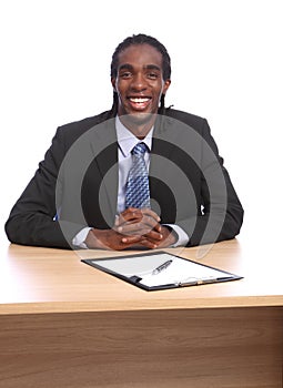 Happy young black businessman sits to office desk