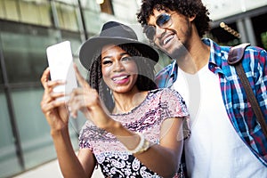 Happy young black couple hugging and laughing outdoors.