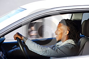 Happy young black man driving car