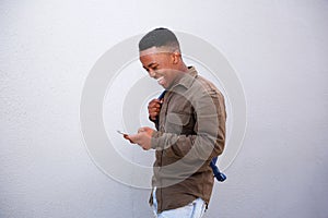 Happy young black man looking at cellphone