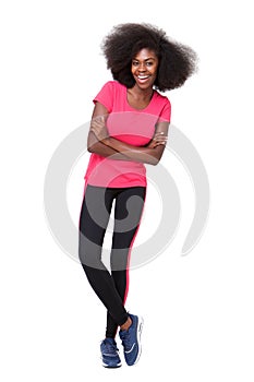 Happy young black sports woman standing against isolated white background