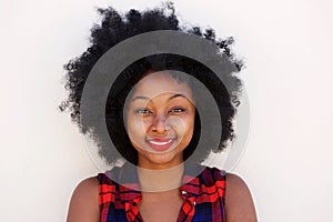 Happy young black woman with afro hairstyle by white wall photo