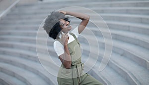 Happy young black woman calling by mobile phone outdoors in the city