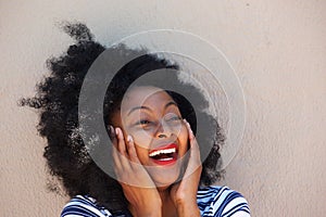 Happy young black woman with head in hands