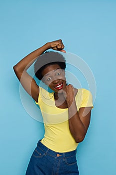 Happy Young Black Woman Is Holding Fists Raised And Smiling