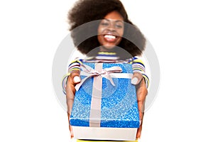 Happy young black woman holding gift box against white background