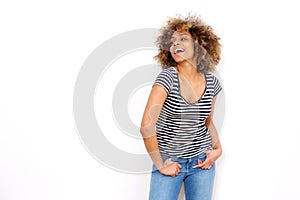 Happy young black woman laughing against white background