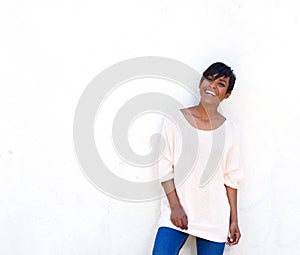 Happy young black woman laughing against white background