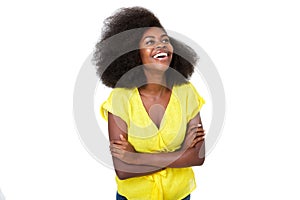 Happy young black woman laughing with arms crossed against isolated white background