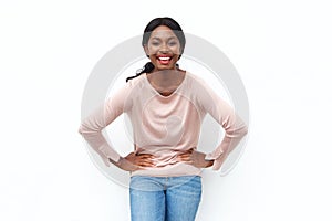 Happy young black woman laughing with hands on hips against isolated white background