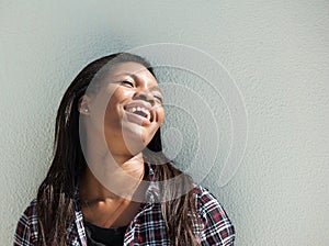 Happy young black woman laughing outdoors