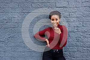 Happy young black woman pointing finger