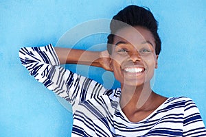 Happy young black woman smiling with hand behind head