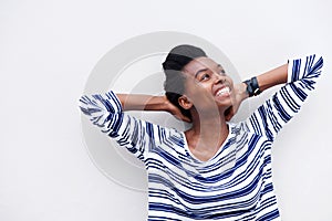 Happy young black woman smiling with hands behind head