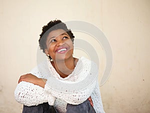 Happy young black woman smiling and looking up