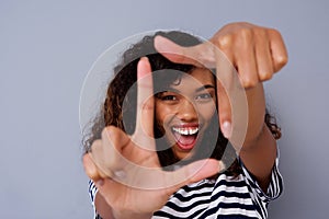 Happy young black woman smiling and making picture frame with fingers