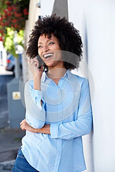 Happy young black woman smiling and talking on cellphone