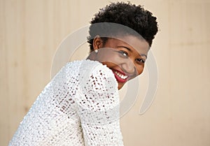 Happy young black woman smiling in white sweater