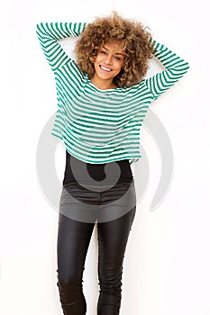 Happy young black woman standing with hands behind head