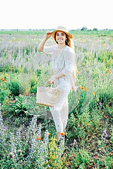Happy young blond woman smiling in the field of poppies