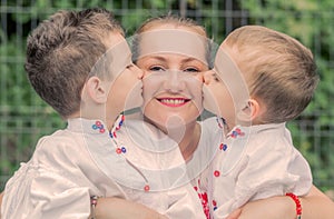 Happy young blonde mother with her two children`s