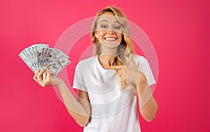 Happy Young Blonde Woman Holding Money Cash Against Pink Backdrop