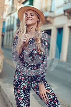 Happy young blonde woman posing at Mediterranean street