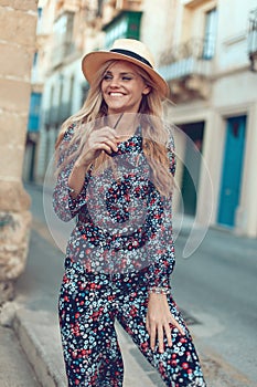 Happy young blonde woman posing at Mediterranean street