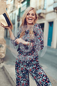 Happy young blonde woman posing at Mediterranean street