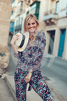 Happy young blonde woman posing at Mediterranean street