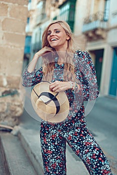 Happy young blonde woman posing at Mediterranean street