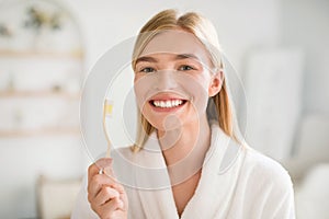 Happy Young Blonde Woman Posing With Toothbrush In Modern Bathroom