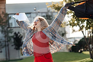 Happy young blonde woman student celebrate success after exams in university.