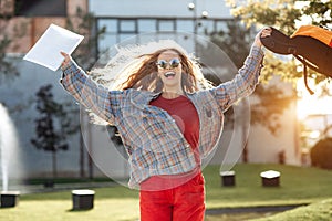 Happy young blonde woman student celebrate success after exams in university.