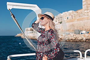 Happy young blonde woman traveling by ferry ship on Mediterranean sea