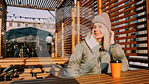 Happy young blonde woman on a winter sunny day at a street food fair