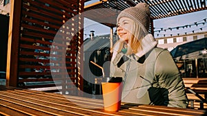 Happy young blonde woman on a winter sunny day at a street food fair