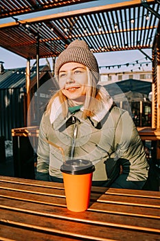 Happy young blonde woman on a winter sunny day at a street food fair