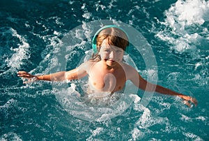Happy young boy child having fun in the water and enjoys summer vacation in the pool. Happy carefree childhood concept