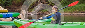 Happy young boy holding paddle in a kayak on the river, enjoying a lovely summer day BANNER, LONG FORMAT