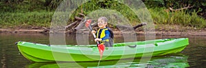 Happy young boy holding paddle in a kayak on the river, enjoying a lovely summer day BANNER, LONG FORMAT