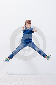 Happy young boy jumping on white background